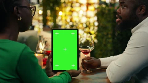 Green screen tablet used by couple bonding at rooftop restaurant table Stock Footage 347084923