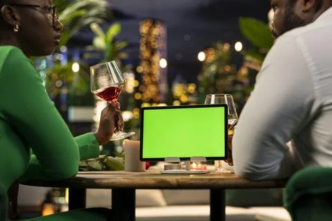 Green screen tablet used by couple during relaxed rooftop restaurant date Fotos Stock