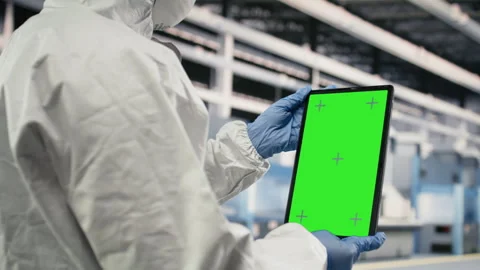 Green screen tablet used by QC engineer to monitor microchip production Stock Footage 333391669