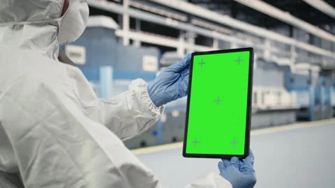 Green screen tablet used by QC engineer to monitor microchip production Stock Footage 333394091