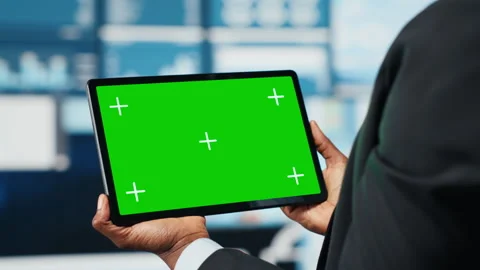 Green screen tablet used by team leader to compare company metrics Stock Footage 318625531