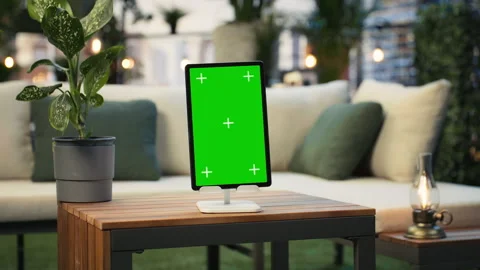 Green screen tablet on wooden table with plants in background, panning shot Stock Footage 345166076