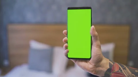 Green screen template smartphone in hands at home in front of the bed Stock Footage 137124658