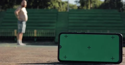 Green screen with tracking dots on phone and fat funny man on background doing Stock Footage 137328289