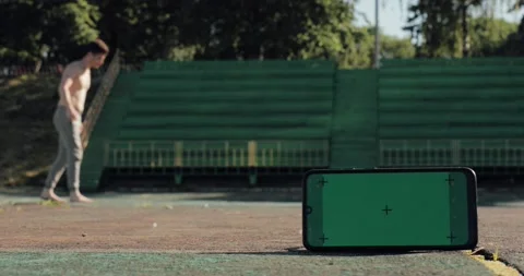 Green screen with tracking dots on phone and attractive fit man on background Stock Footage 137329979