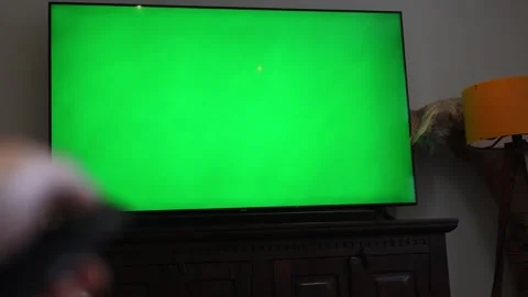 Green screen tv. man holding remote control turning on tv changing channels. gre Stock Footage 303100719