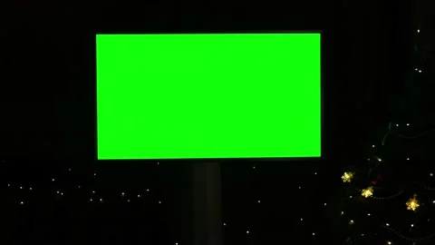 Green screen TV mockup on black background with flashing lights on Christmas Stock Footage 220116122