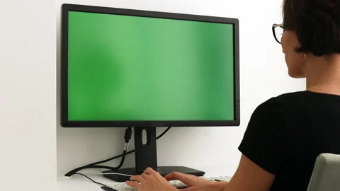 Green screen. Woman working at computer sitting at desk. View from back. Stock Footage 219791520