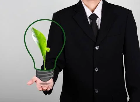 Green seedling in light bulb on hand businessman Illustration