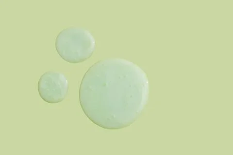 Green serum drop on Green background. Liquid gel moisturizer Stock Photos