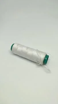 Green sewing thread and needle stuck in sewing thread Stock Photos