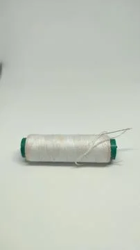 Green sewing thread and needle stuck in sewing thread 스톡 사진