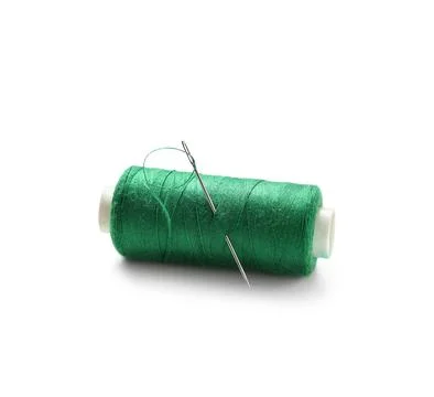 Green sewing thread spool with needle isolated on white background, closeup Stock Photos