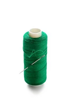 Green sewing thread spool with needle isolated on white background, closeup Stock Photos