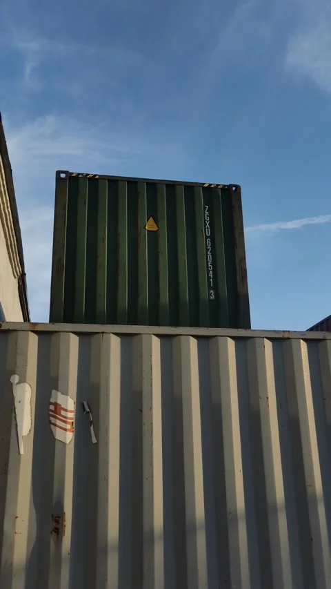 Green shipping container stacked on top of a grey one Stock Footage 334436027