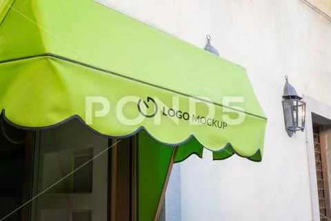 Green shop awning logo mockup above storefront window for visual identity bra Template PSD