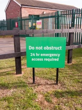 Green sign do no obstruct 24 hr emergency access required Stock Photos