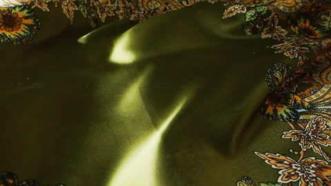 Green silk fabric with floral pattern waving in the wind. Smooth textile waves. Video stock 332993597