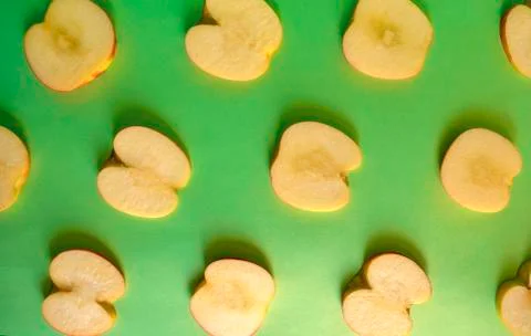Green sliced apple pattern on green background. Fruit flat lay of apples Stock Photos