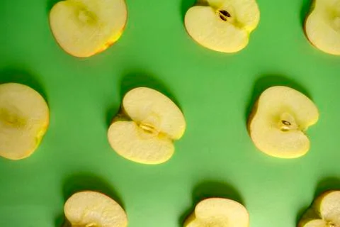 Green sliced apple pattern on green background. Fruit flat lay of apples Stock Photos