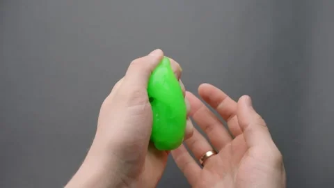 Green slime passed from left to right hand and back during ASMR tactile session Stock Footage 310588526