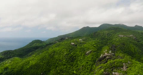 Green slopes dotted with massive gray rocks. Mahe, Seychelles. Stock Footage 302140238