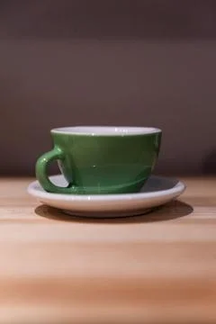 Green small cup on the table. Image contains excessive noise Stock-Fotos