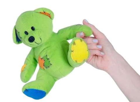 Green small soft toy bear in hand Stock Photos