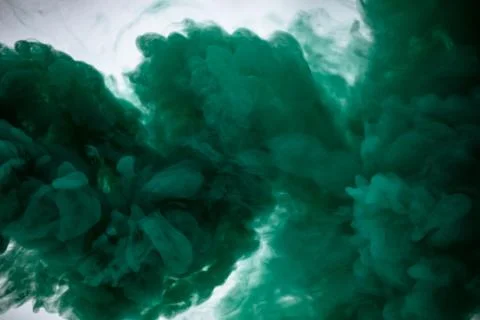 Green smoke bomb exploding against white background Stock Photos