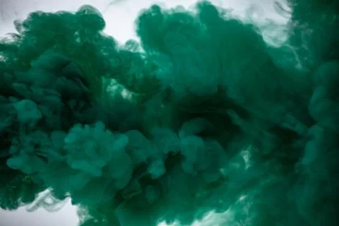 Green smoke bomb exploding against white background Stock Photos