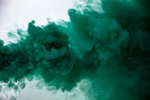 Green smoke bomb exploding against white background Stock Photos