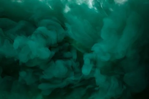Green smoke bomb exploding against white background Foto stock