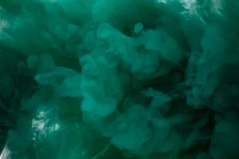 Green smoke bomb exploding against white background Stock Photos