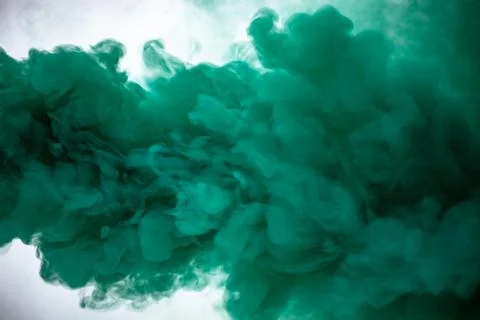 Green smoke bomb exploding against white background Stock Photos