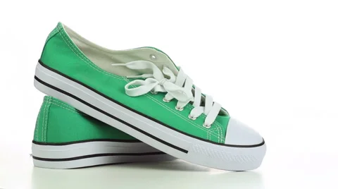 Green sneakers revolve on a white background Stock Footage 49365769