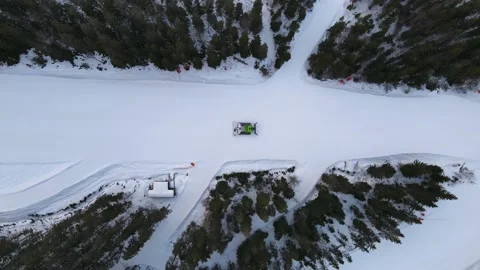 Green snowcat driving down an empty ski slope an early evening in the spring. Stock Footage 151024297