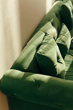 Green sofa with pillows top angle view during sunset at home 库存照片