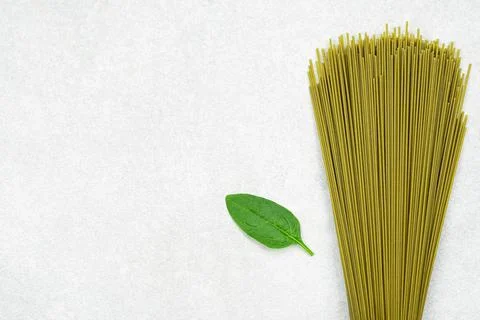 Green spaghetti with spinach leaf on gray background Stock Photos