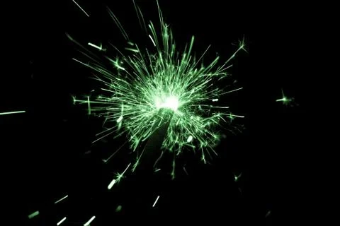 Green sparkler countdown on fire with spread of glitter sparks. Luxury entert Stock Photos