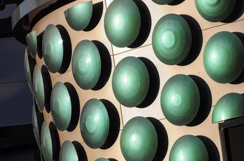 Green spherical architecture elements casting shadows on building facade 스톡 사진