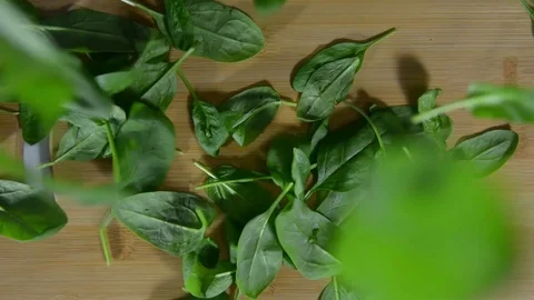 Green spinach leaves fall on the table, top view Stock Footage 122908872