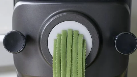 Green spinach pasta dough transformed into fresh homemade tagliatelle Stock Footage 338045482