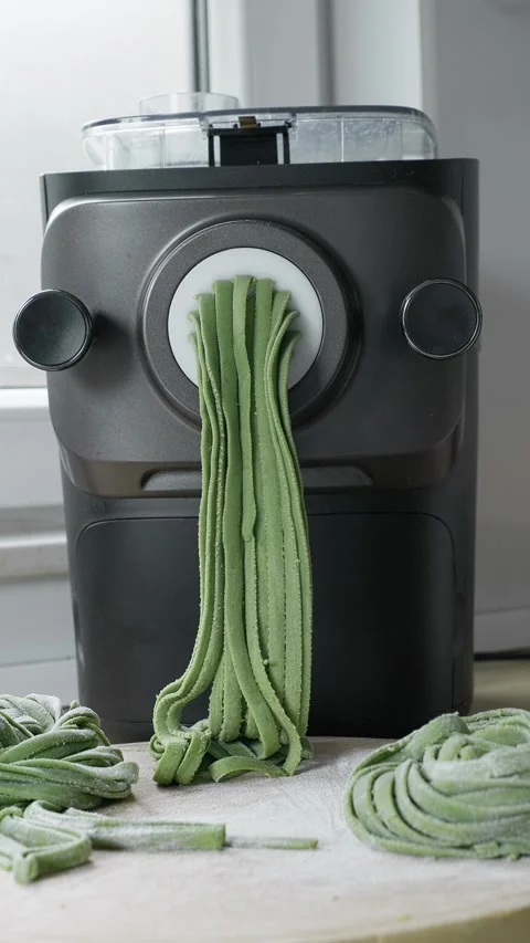 Green spinach pasta dough transformed into fresh homemade tagliatelle Stock Footage 338045490