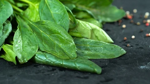 Green spinach slowly falls on the table Slow motion Stock Footage 113454924