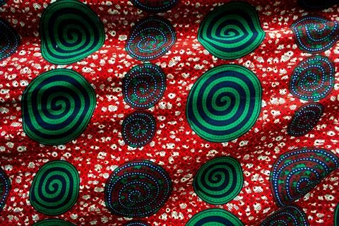 Green spiral pattern on a red background Foto stock