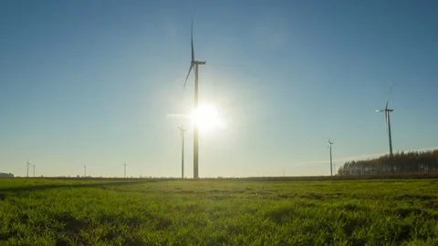 Green spring field with windmills and sunset sky in 4k time lapse. Stock Footage 164303080