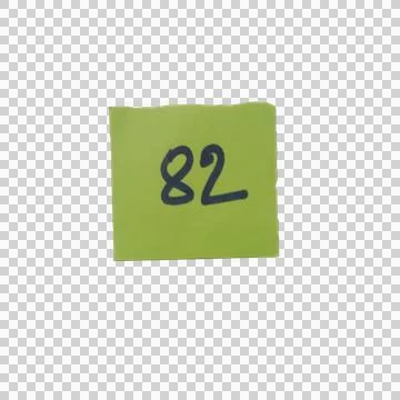Green square sticky note with number eighty two written in black ink Фото