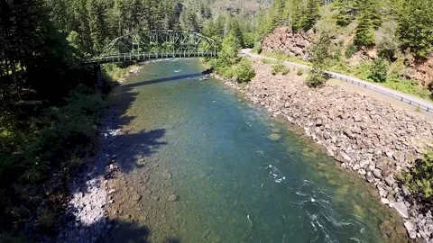 Green Steel Bridge Spanning a River in a Forested Area Vidéo 348217455