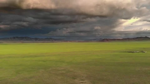Green steppe beneath storm clouds - Serene Isolation and Atmospheric Landscape Stock Footage 339714102