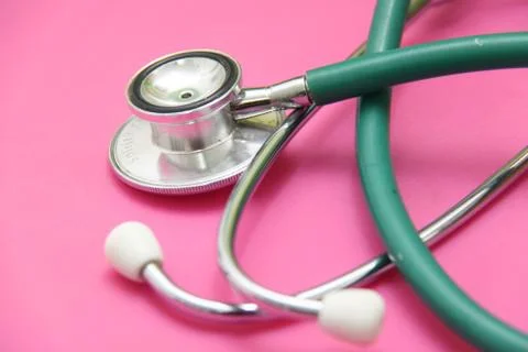 Green stethoscope isolated on pink background Stock Photos